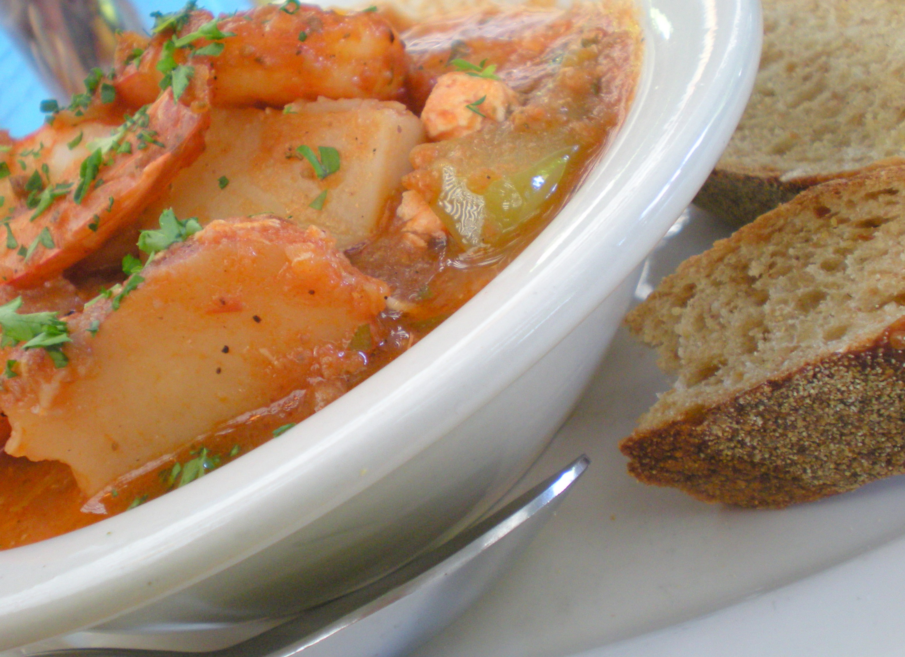 Fresh Seafood Rgout: Salmon, shrimp simmered with herbs, saffron and citrus served with toasted baguette slices