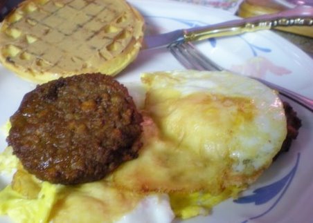 A husband's breakfast after shot: Peanut butter smoothered waffle, Morning Star Patties, 3 fried Eggs