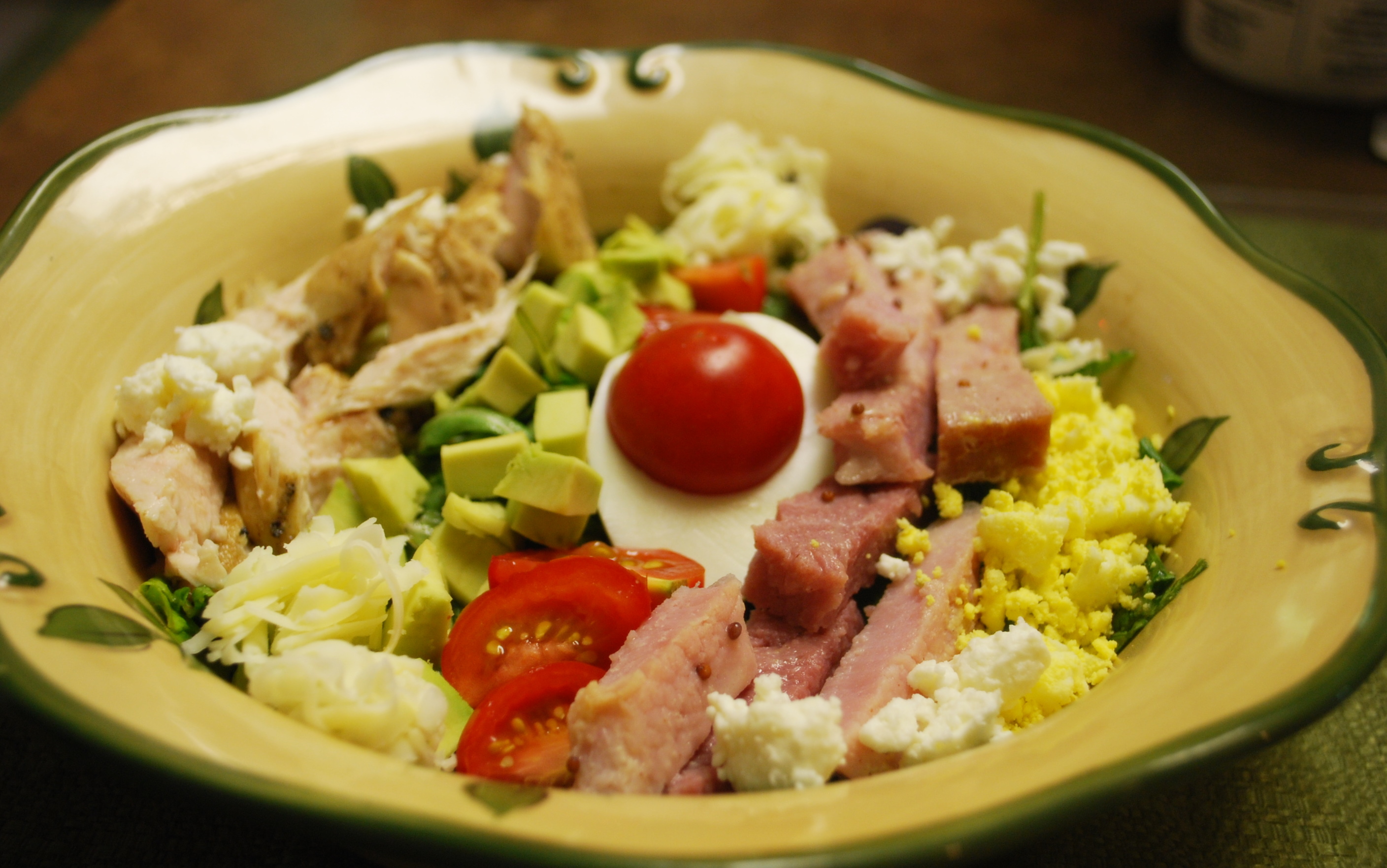 Cobb Salad: Romaine, Baby spinach, Baby arugula, chicken, ham, egg, tomatoes, avocado, feta and cheddar cheese in home made dressing.