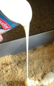 Pour the sweetened condensed milk on top of the crumbs