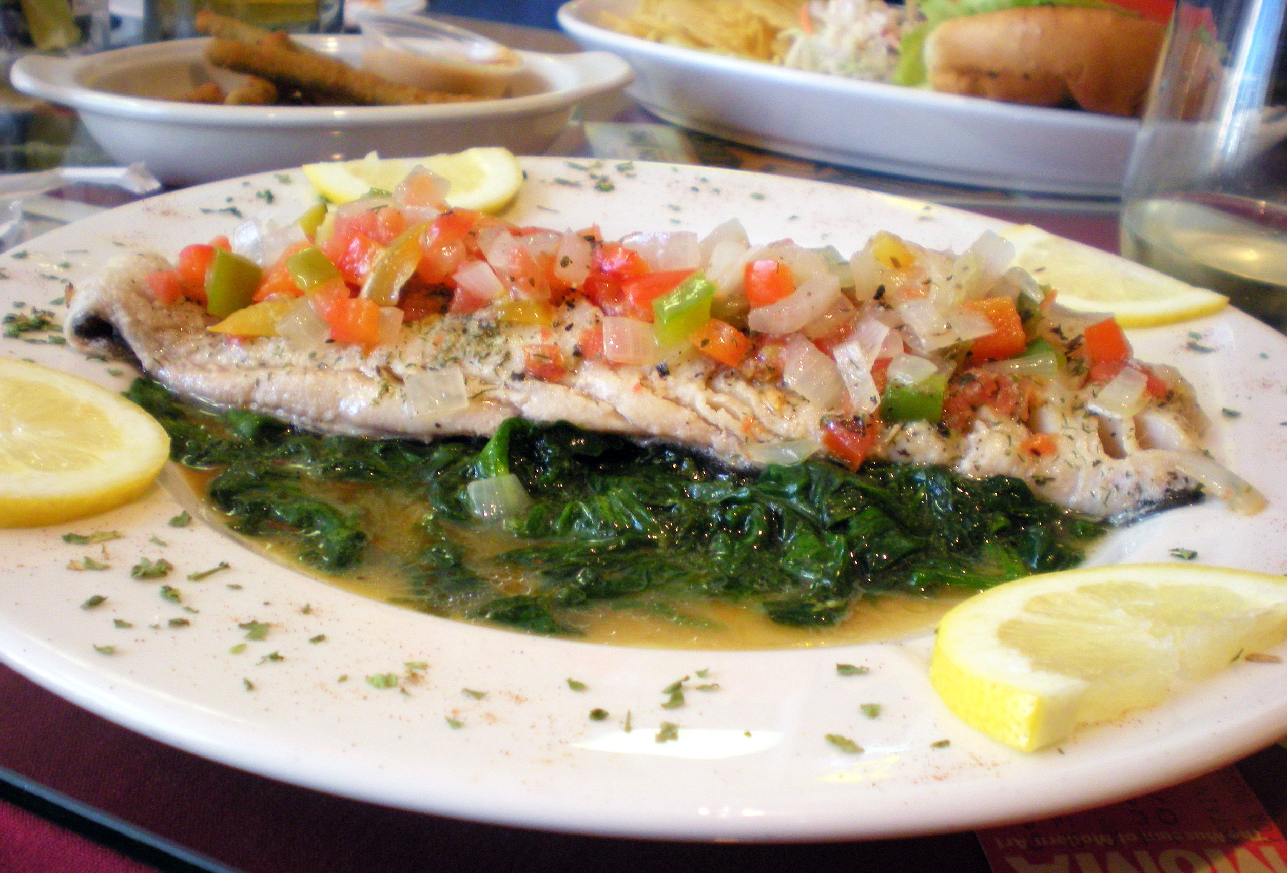 Haddock Florentine: 10 ounces of fresh haddock baked in Chablis and lemon. The fish is topped with onions, peppers, tomatoes and served with fresh sauteed spinach.